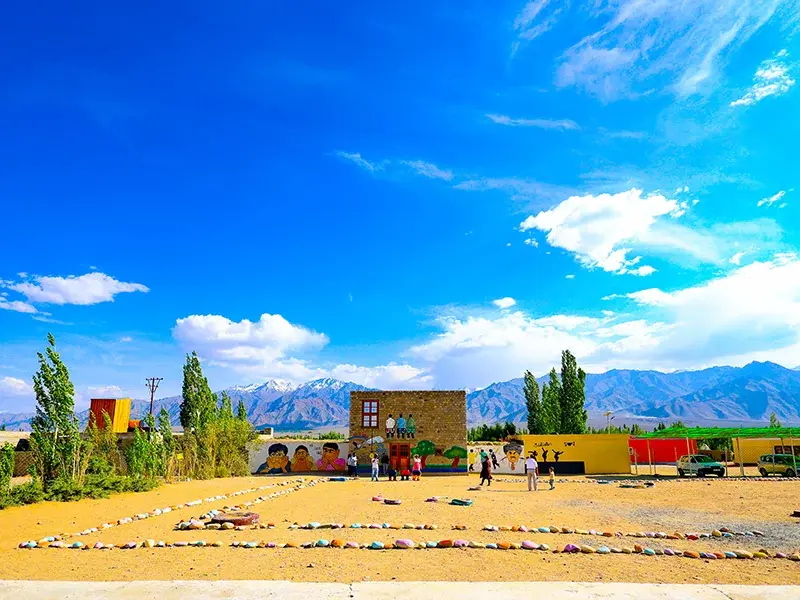 Rancho School Ladakh courtyard with mountain backdrop and colorful educational murals